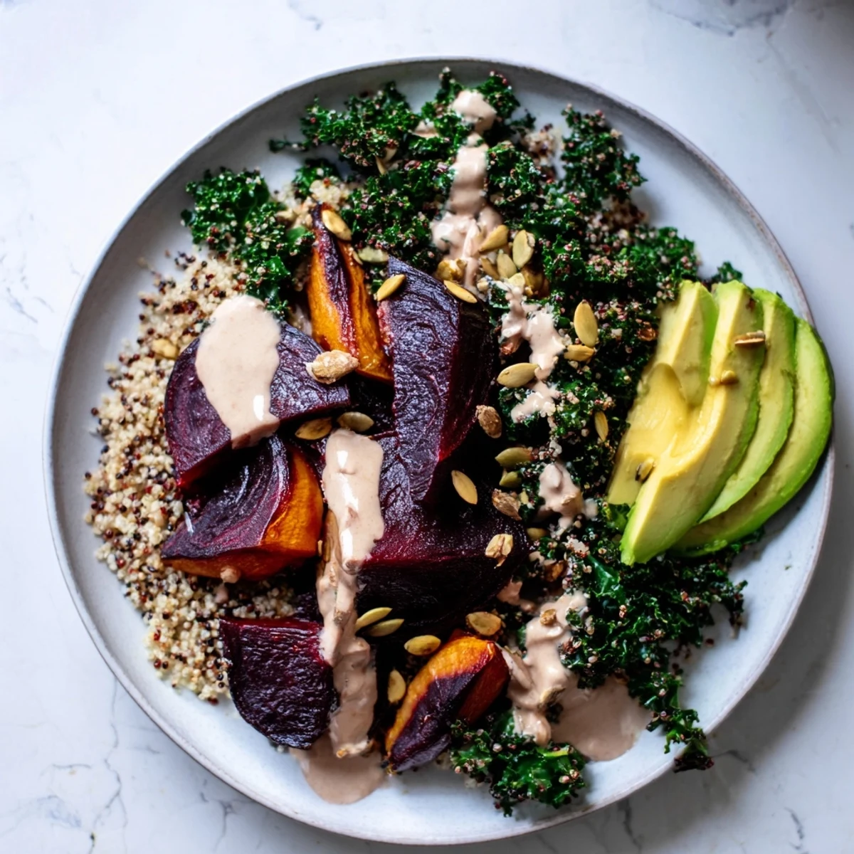 A colorful Quinoa, Kale & Roasted Beet Bowl: Fluffy quinoa with vibrant beets, kale, and creamy tahini dressing.