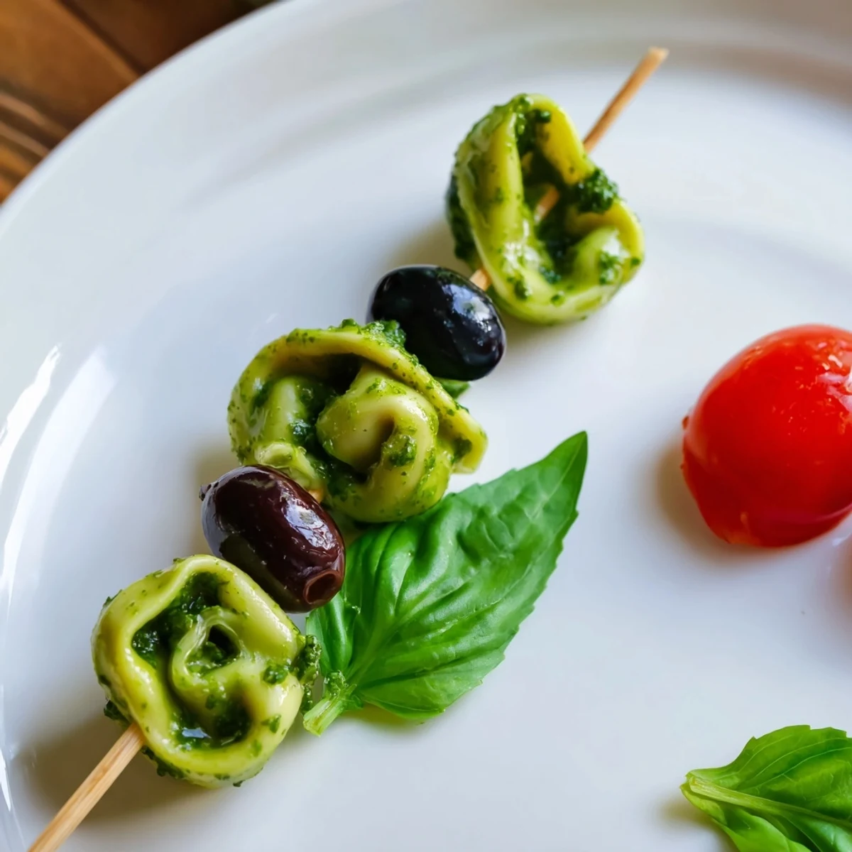 See vibrant Appetizer Skewers: tortellini, pesto and olives, a vegetarian delight, ready for easy snacking.