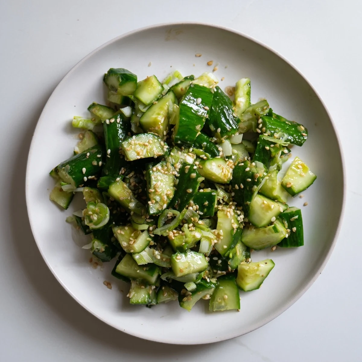 Fresh Cucumber Shaker salad glistening with sesame oil, ready for a cool, savory bite.