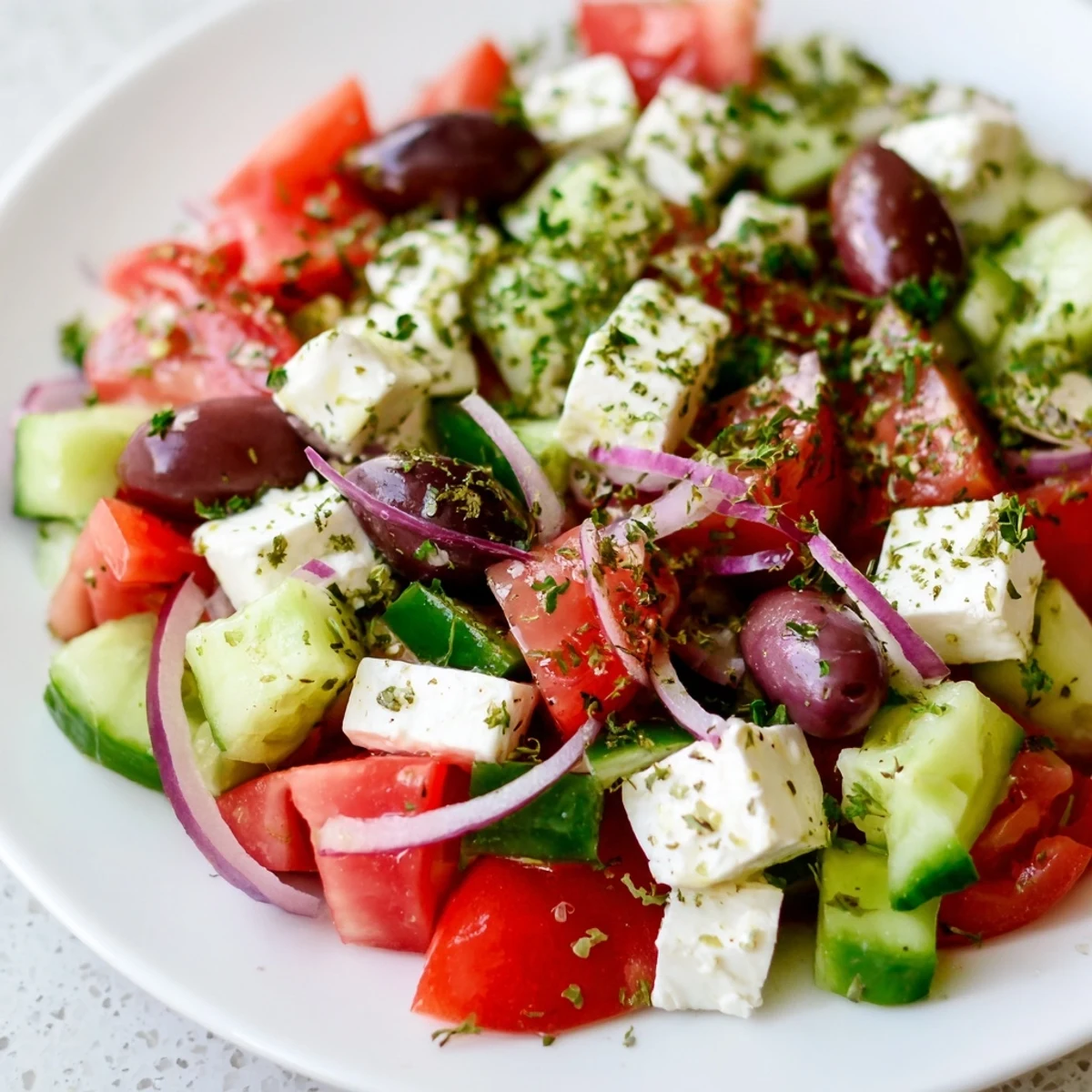 Vibrant Mediterranean Salad with juicy tomatoes, olives, and creamy feta, drizzled with olive oil.