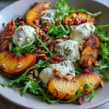 Fresh burrata atop caramelized peaches and peppery arugula, drizzled with honey.