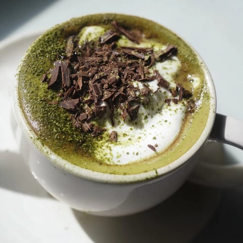 Steaming Matcha Hot Cocoa Protein Mug topped with whipped cream, perfect for a cozy morning.