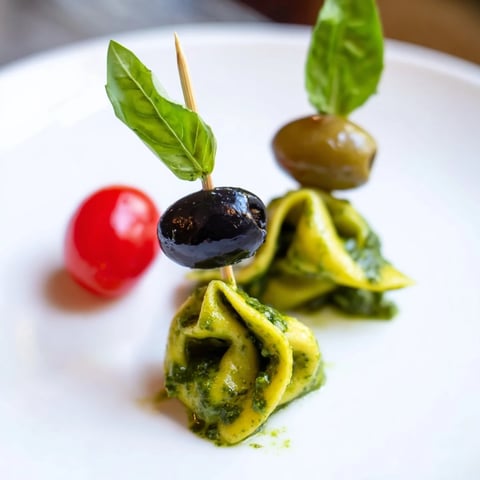 Appetizer Skewers: Tortellini, pesto, and olive skewers, a colorful Italian appetizer ready to serve with a drizzle.