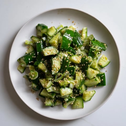 Fresh Cucumber Shaker salad glistening with sesame oil, ready for a cool, savory bite.