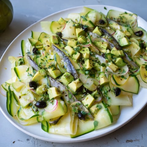 Close-up of a refreshing Cucumber and Tinned Fish Salad with vibrant greens and creamy avocado, ready to eat.