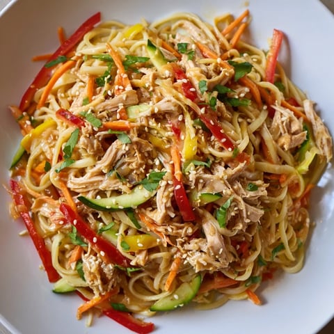 Vibrant chilled chicken noodle salad, featuring tender chicken and crisp veggies coated in sesame dressing.