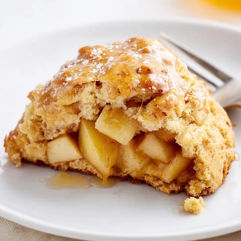 Close-up of glazed Cinnamon Honey Apple Scones sprinkled with sugar, inviting warmth.