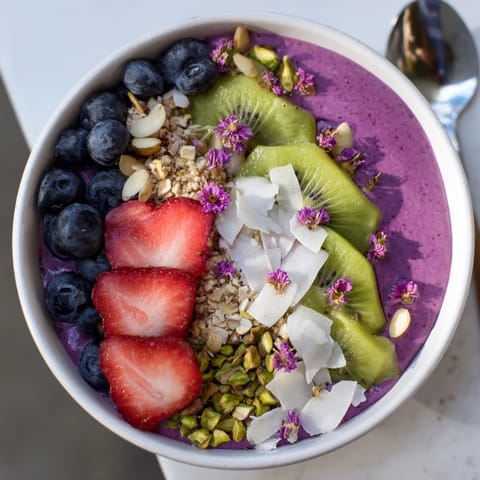Delightful breakfast bowl filled with colorful fruits and creamy purple yam smoothie.  