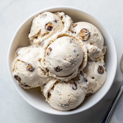 A bowl of cottage cheese ice cream topped with edible cookie dough and chocolate chips.  
