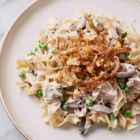 A close-up of creamy Tuna Noodle Casserole, showcasing the crunchy fried onion topping.