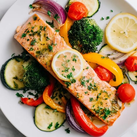 Golden-brown salmon fillets resting on a bed of vibrant vegetables in this easy sheet pan bake.