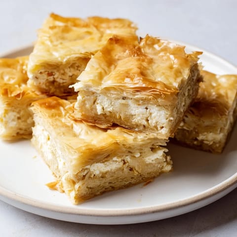 Golden, flaky Bulgarian Banitsa, a savory pastry with a creamy feta and egg filling.