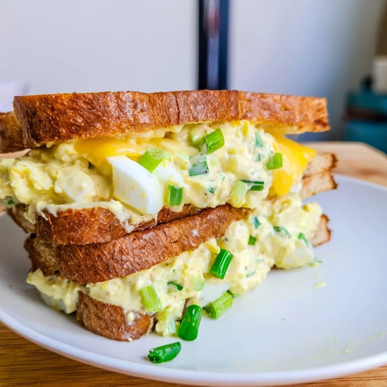 Freshly made Egg Salad Grilled Cheese, oozing with melted cheese, promising a comforting, satisfying lunch.