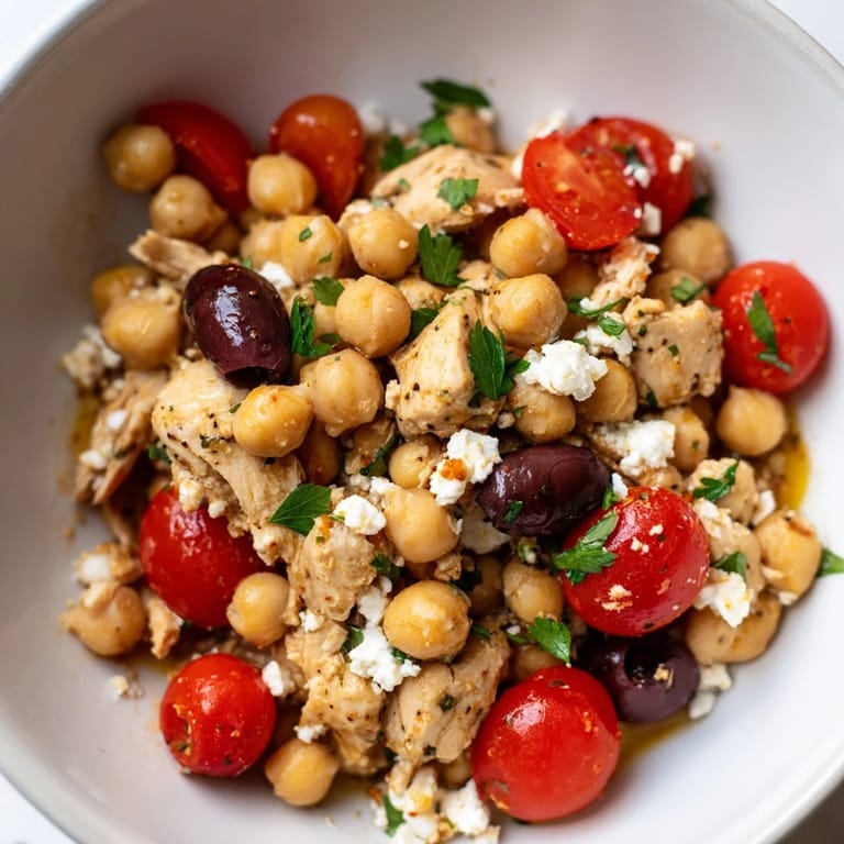 Serving suggestion for Mediterranean Chickpea Chicken Salad on a lightened plate with a lemon wedge and fresh parsley garnish.
